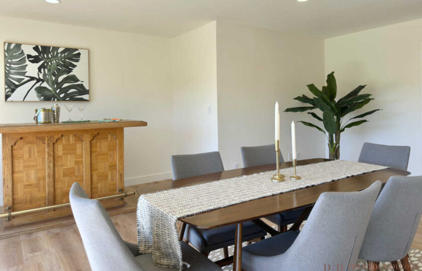 Woodland Hills MCM home staging featuring vintage wood bar, mid-century dining set, and tropical plants.