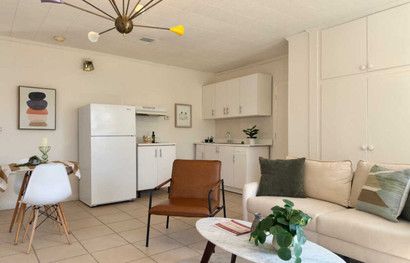 Woodland Hills MCM home staging featuring small retro kitchen, brown armchair, white sofa, and sputnik chandelier.