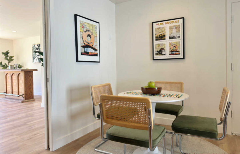 Woodland Hills MCM home staging with round dining table, green velvet and cane chairs, and vintage art.