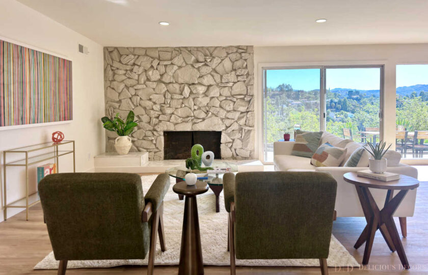 Woodland Hills MCM home staging featuring a stone fireplace, olive armchairs, white sofa, shag rug, and colorful art.