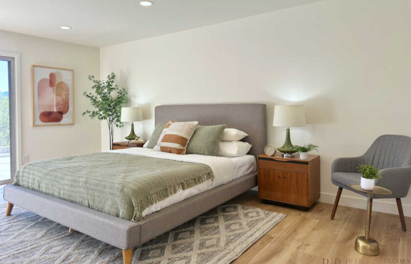 Woodland Hills MCM home staging with a grey upholstered bed, green blankets, walnut nightstands, and retro lamps.