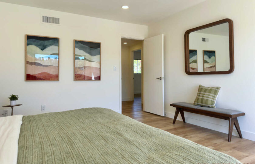 Woodland Hills MCM home staging showing a platform bench, retro mirror, and framed landscape prints.